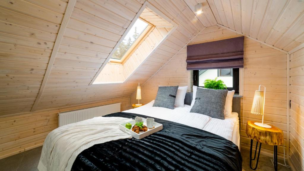 Un dormitorio con una cama con una bandeja de comida. en HELLO APARTAMENTY - Szyszka dwupoziomowa, en Karpacz