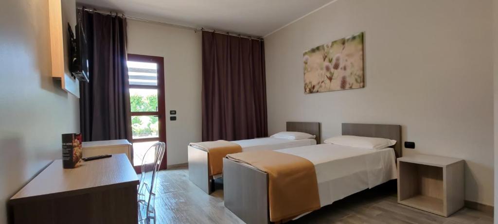pokój hotelowy z 2 łóżkami i oknem w obiekcie Break Hotel w mieście Ospedaletto Lodigiano