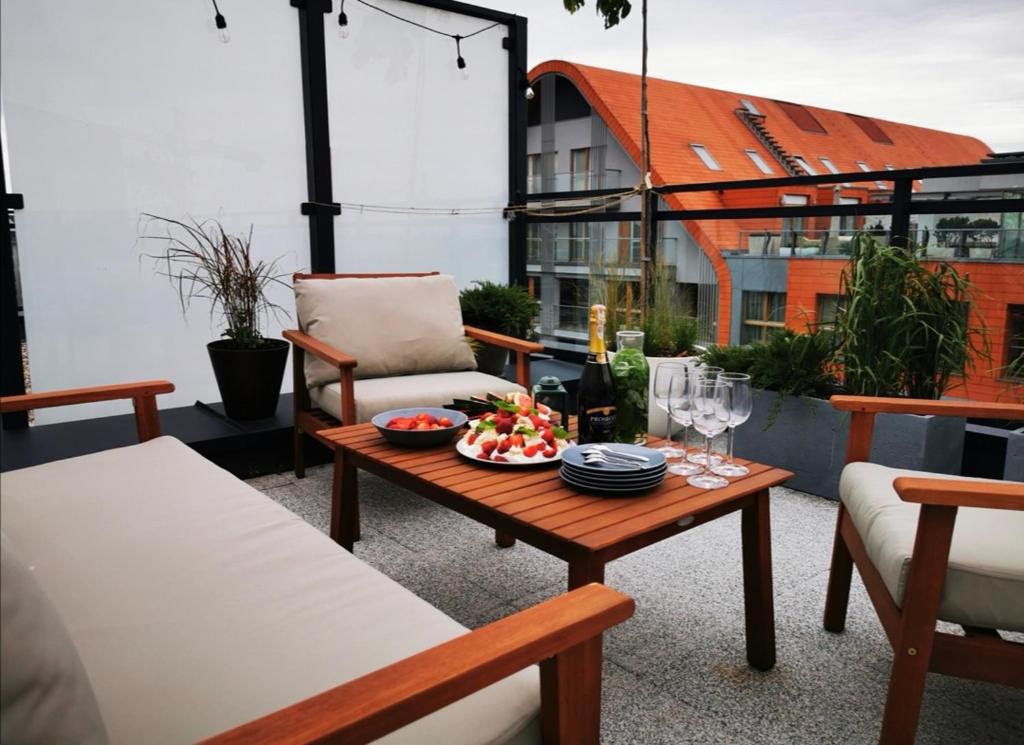 a balcony with a table with food and wine glasses at Trident Apartment III in Gdańsk