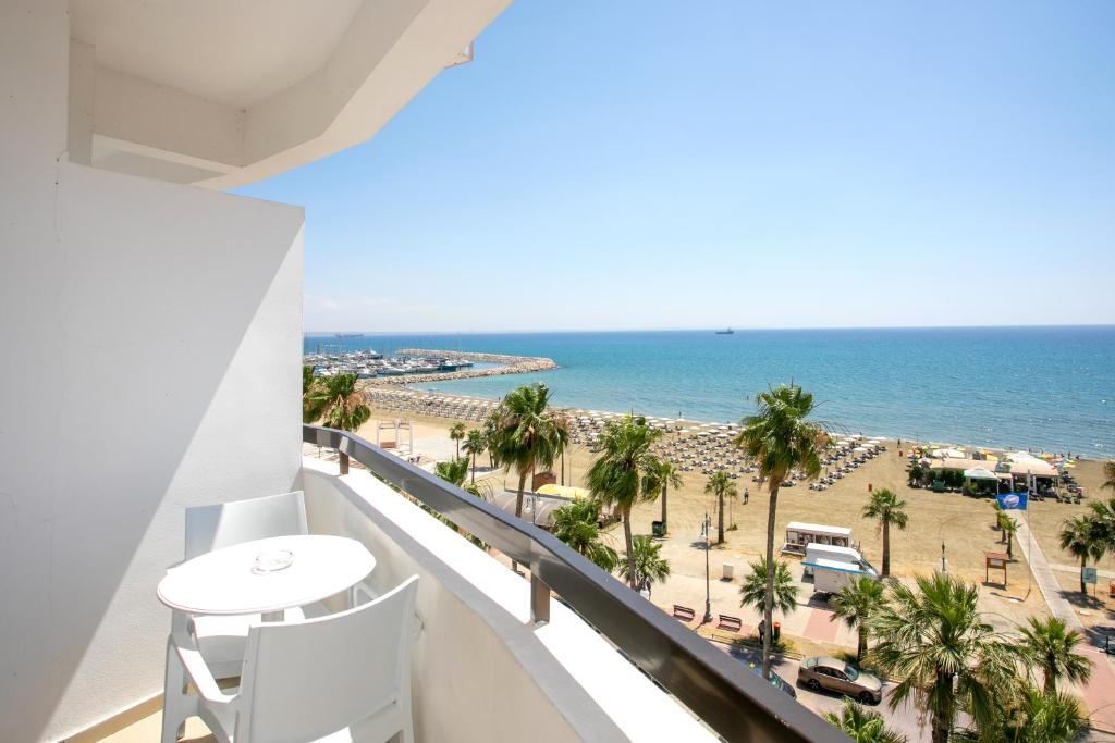 uma varanda com vista para a praia e para o oceano em Les Palmiers Beach Boutique Hotel & Luxury Apartments em Lárnaca