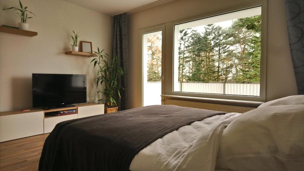 a bedroom with a bed and a large window at Melia in Hamm