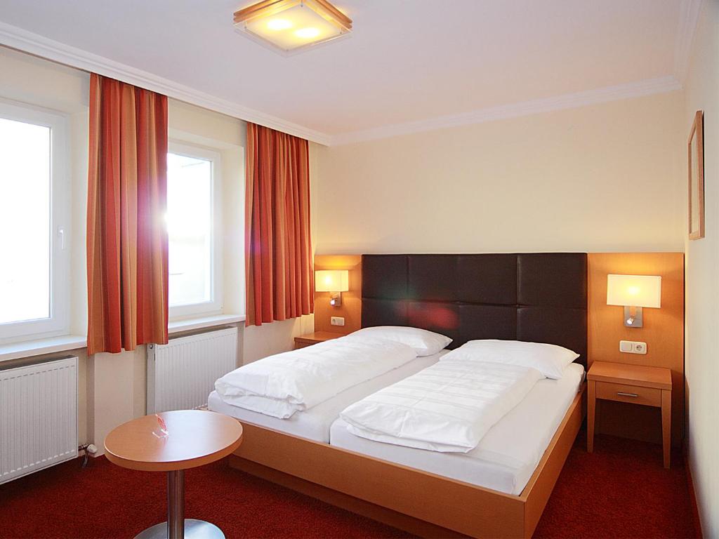 
a hotel room with two beds and two lamps at Hotel Goldener Adler in Linz
