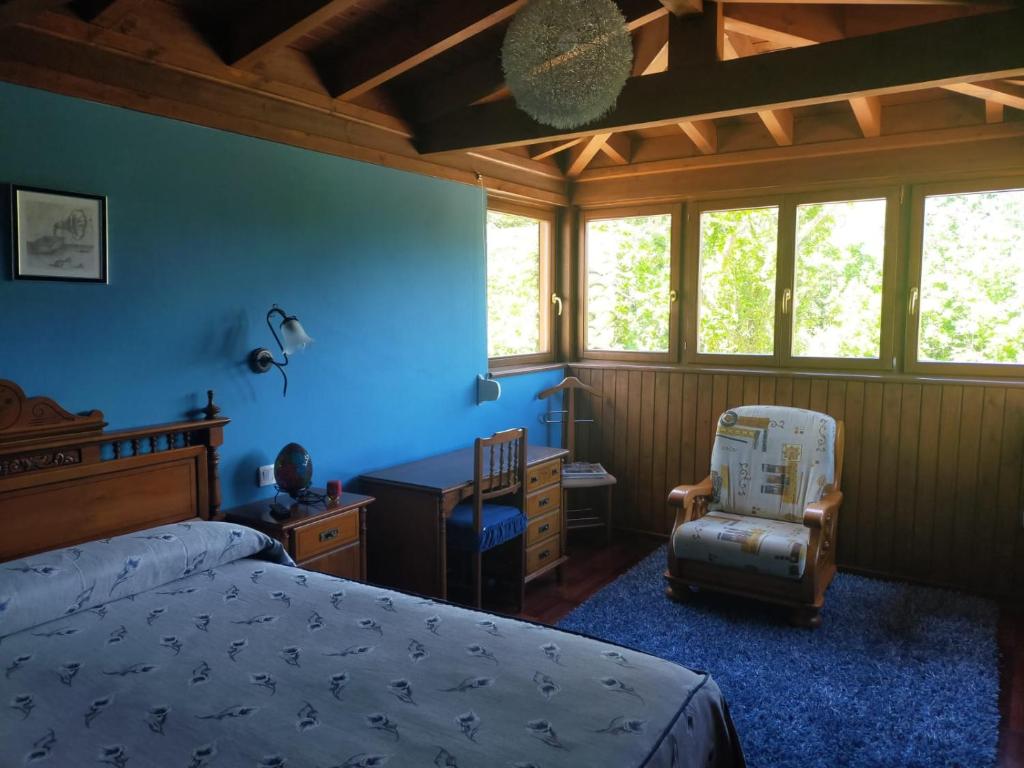 een slaapkamer met een bed, een bureau en een stoel bij Villalen in Cuerres