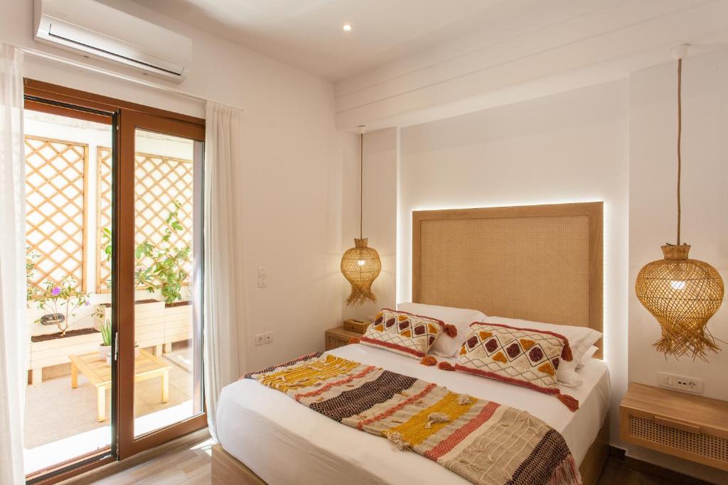 een witte slaapkamer met een bed en een raam bij Blue Jasmine Apartments in Chania