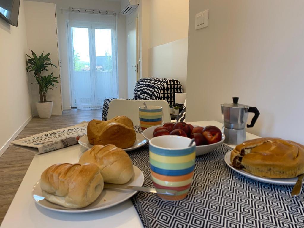 a table with plates of bread and fruit on it at La Pergola in Trieste