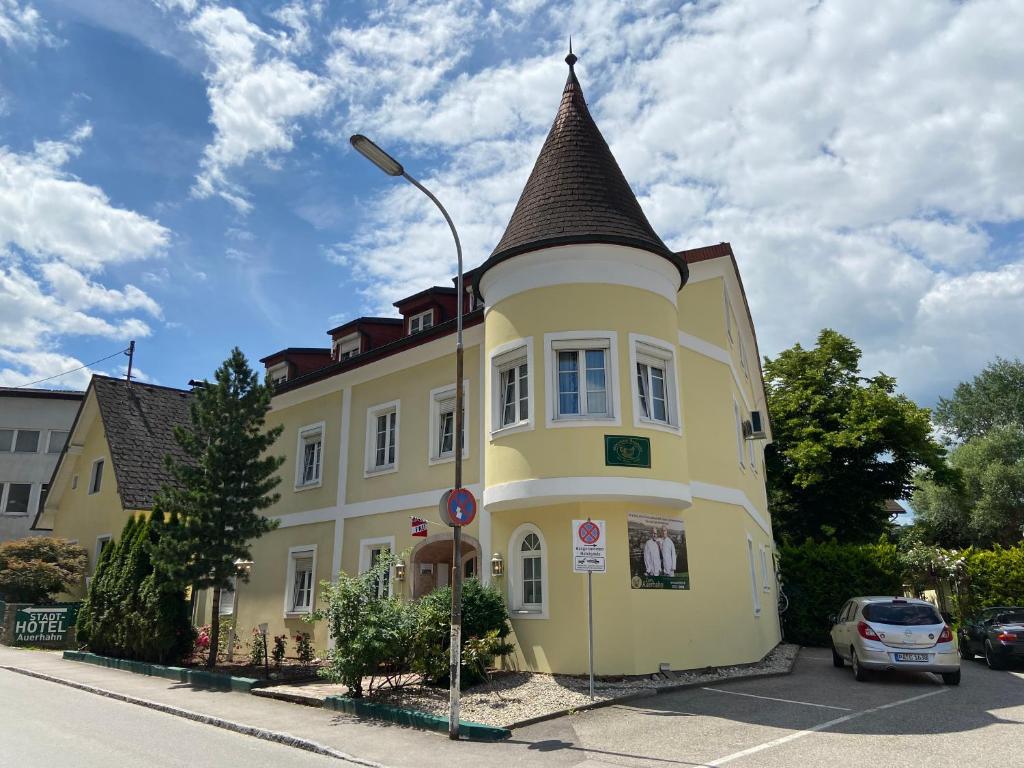 un edificio amarillo con una torreta en una calle en Gästehaus Auerhahn, en Vöcklabruck