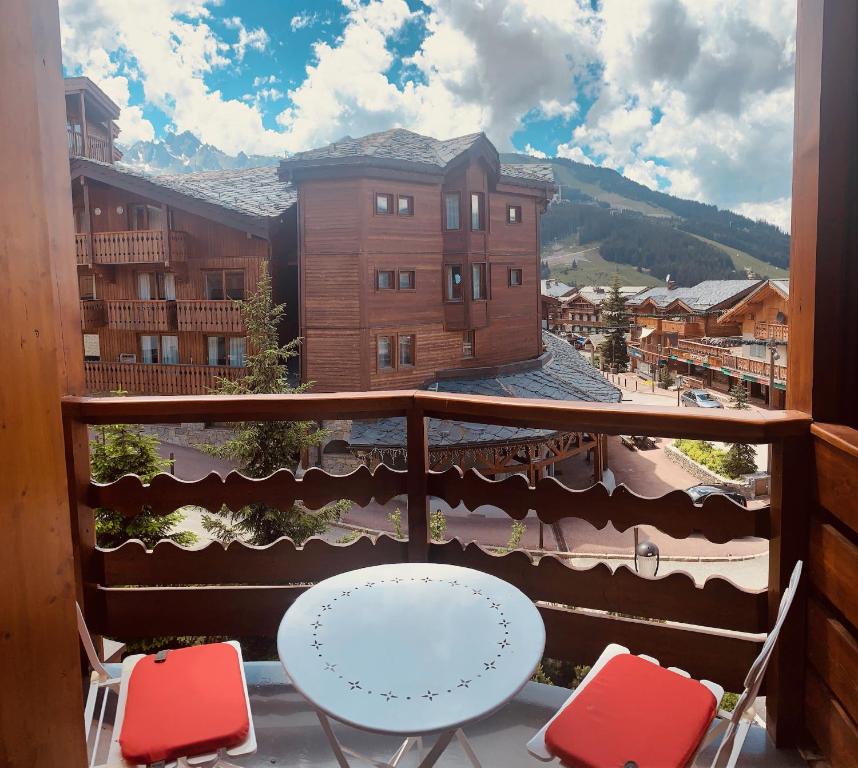 einen Balkon mit 2 Stühlen und einem Tisch auf dem Balkon in der Unterkunft Le Marquis Courchevel in Courchevel
