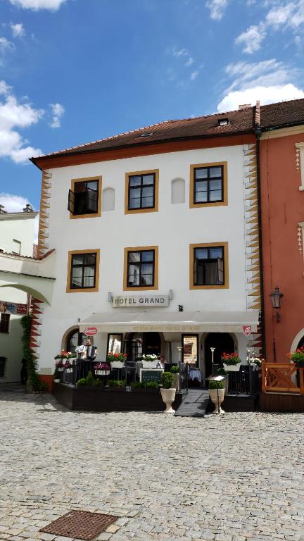 un gran edificio blanco con un cartel. en Hotel Grand, en Český Krumlov