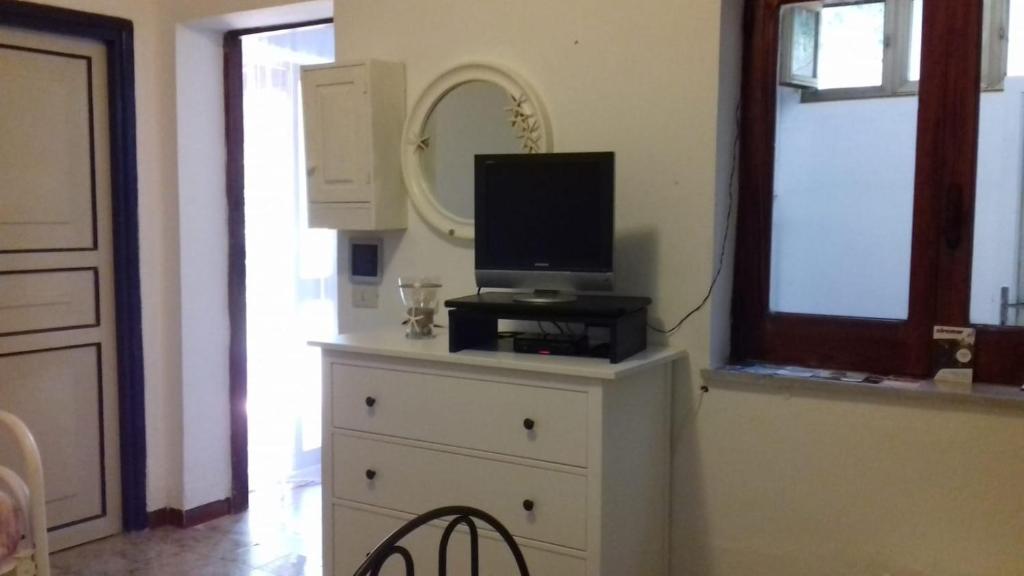 una TV sopra un comò con specchio di Villetta dei Limoni a Vulcano
