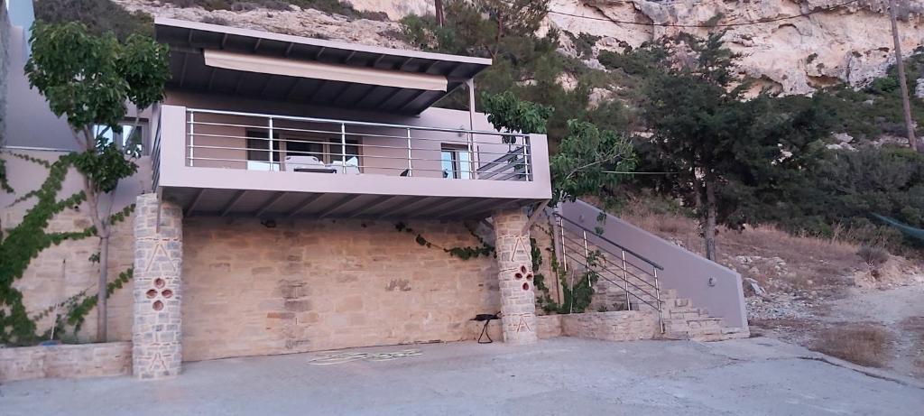 a house with a balcony on top of it at Villa Dream in Matala