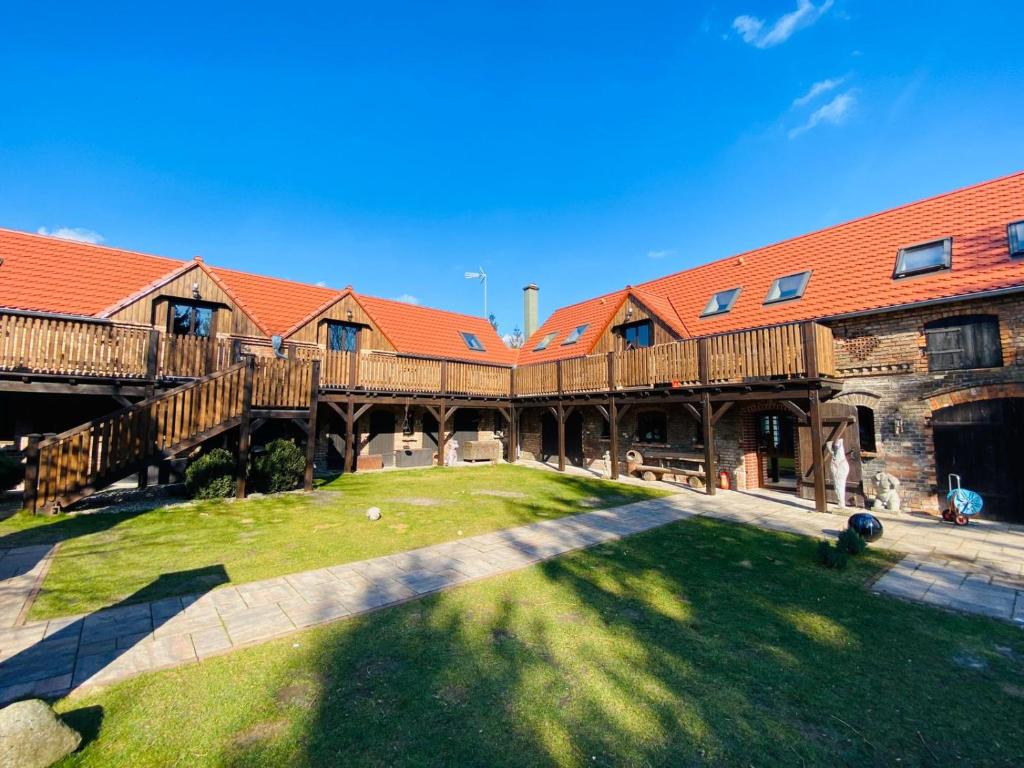 un gran edificio de madera con un patio de césped delante de él en Agroturystyka Hanka i Jurek, en Boruja