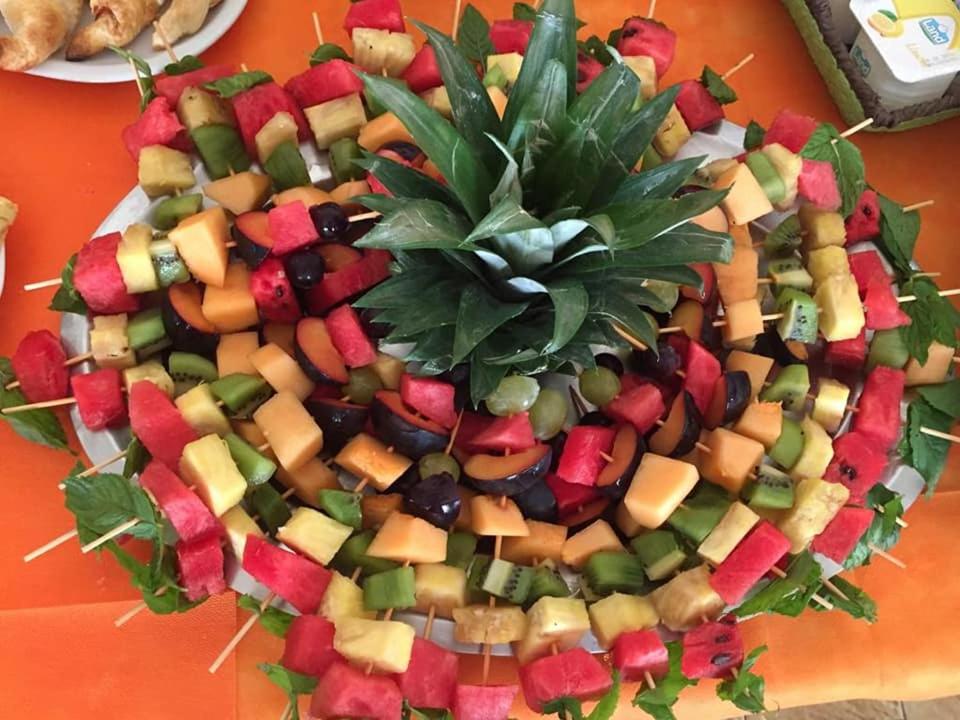 a plate of fruits and vegetables on a table at Hotel La Favorita in Peschiera del Garda