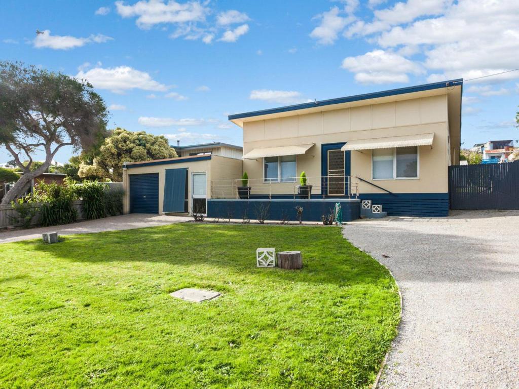 a house with a green lawn in front of it at Ocean Sounds in Anglesea