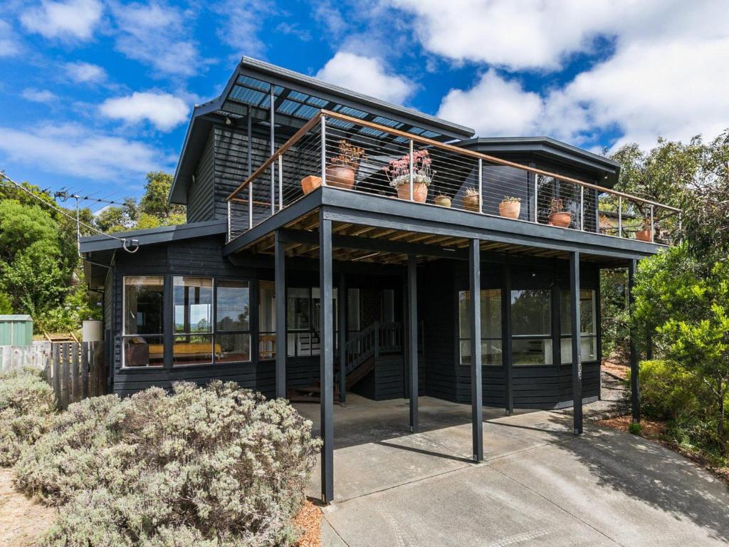 a black house with a balcony on top of it at Niche On Noble in Anglesea