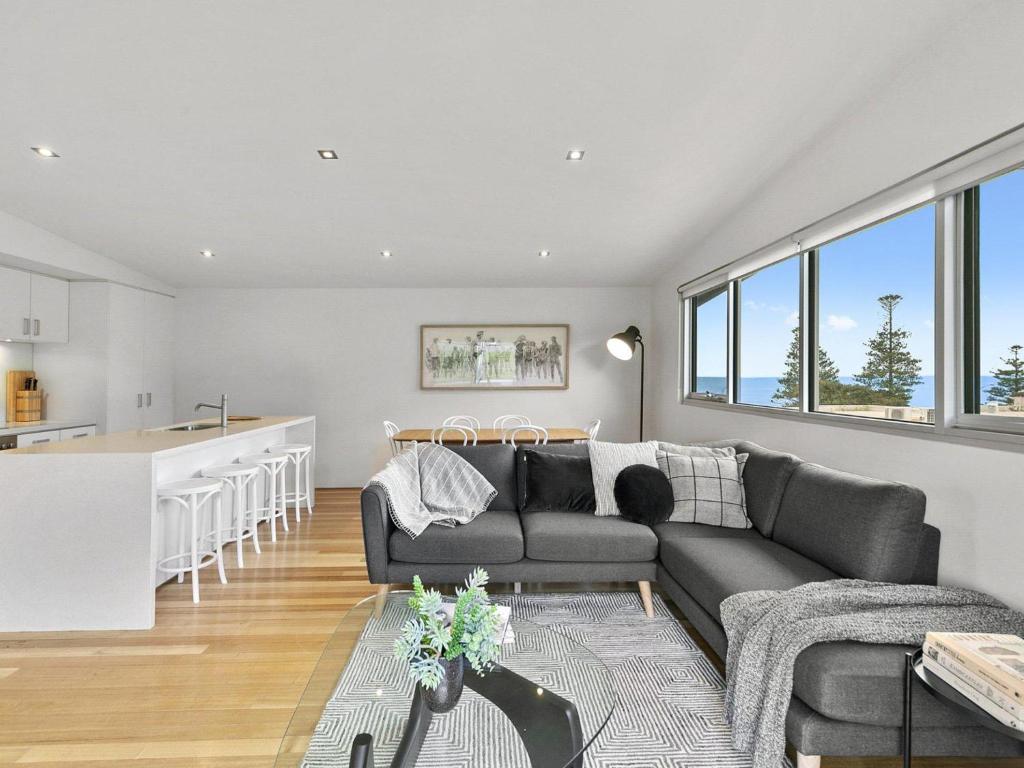 a living room and kitchen with a couch and a table at Surf Central in Lorne