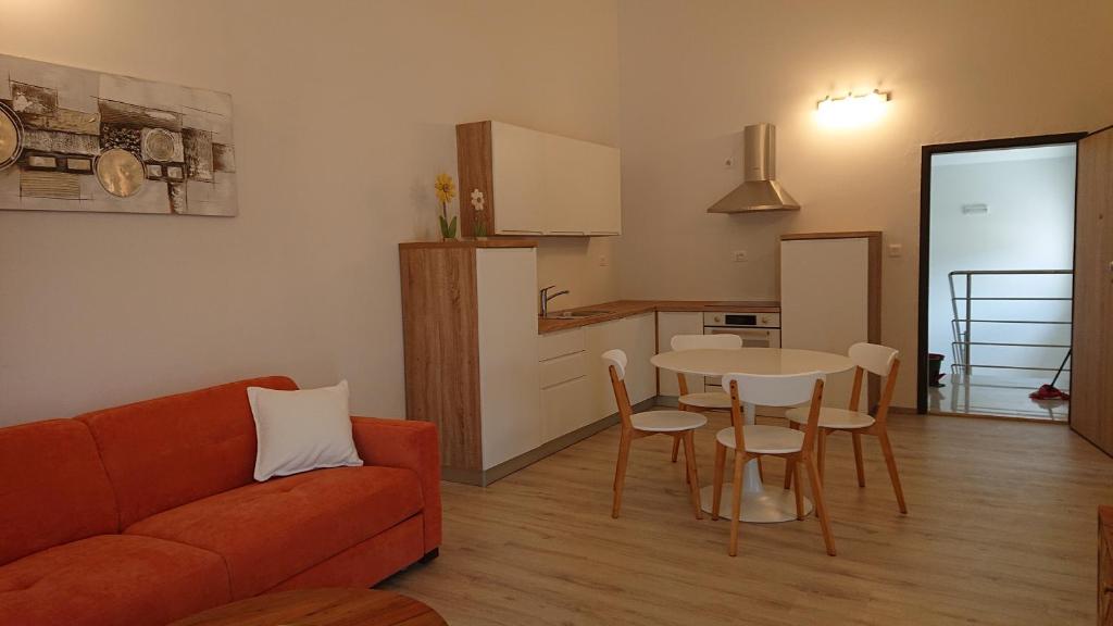 a living room with a couch and a table and a kitchen at Irena in Cres
