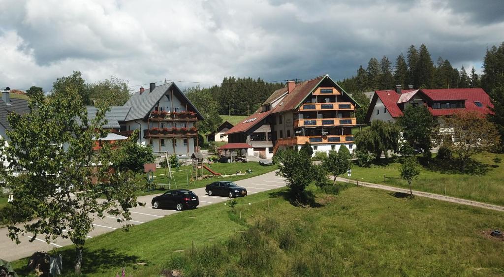 a town with houses and cars on a road at Café-Pension Feldbergblick in Titisee-Neustadt