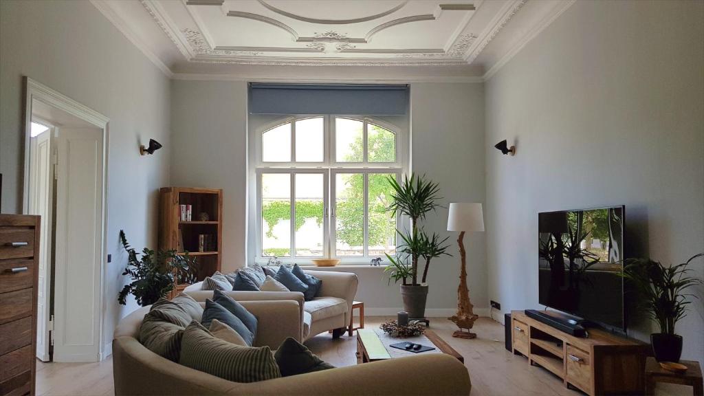 a living room with a couch and a tv at Andrés Ferienwohnung DELUXE in Cottbus