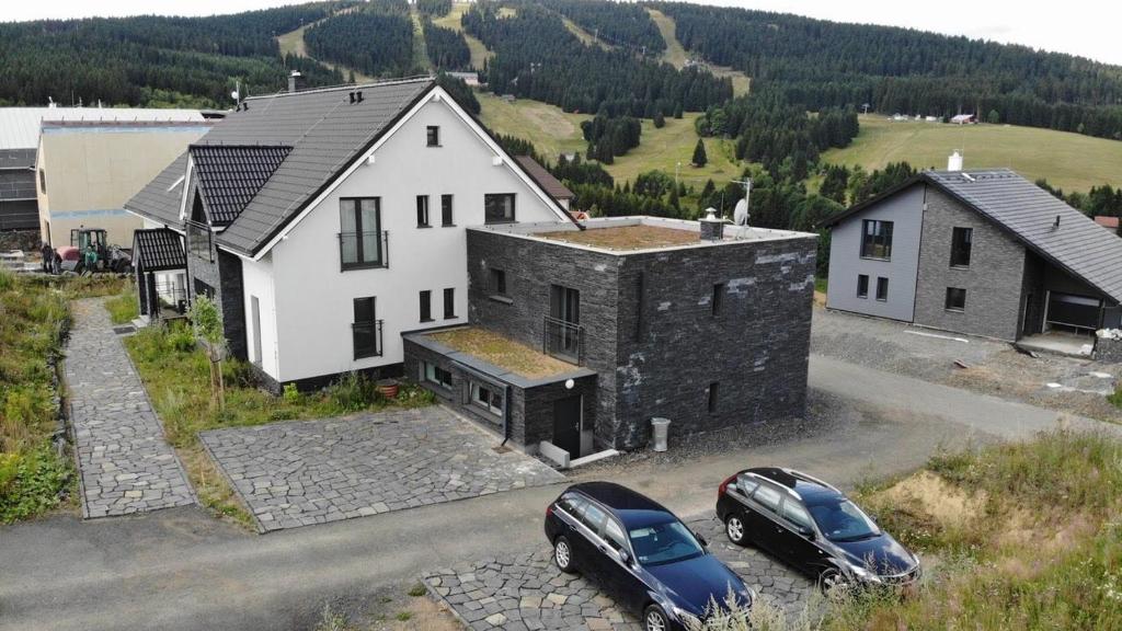 dwa samochody zaparkowane przed domem w obiekcie Ski Villa Rubicon w mieście Loučná pod Klínovcem