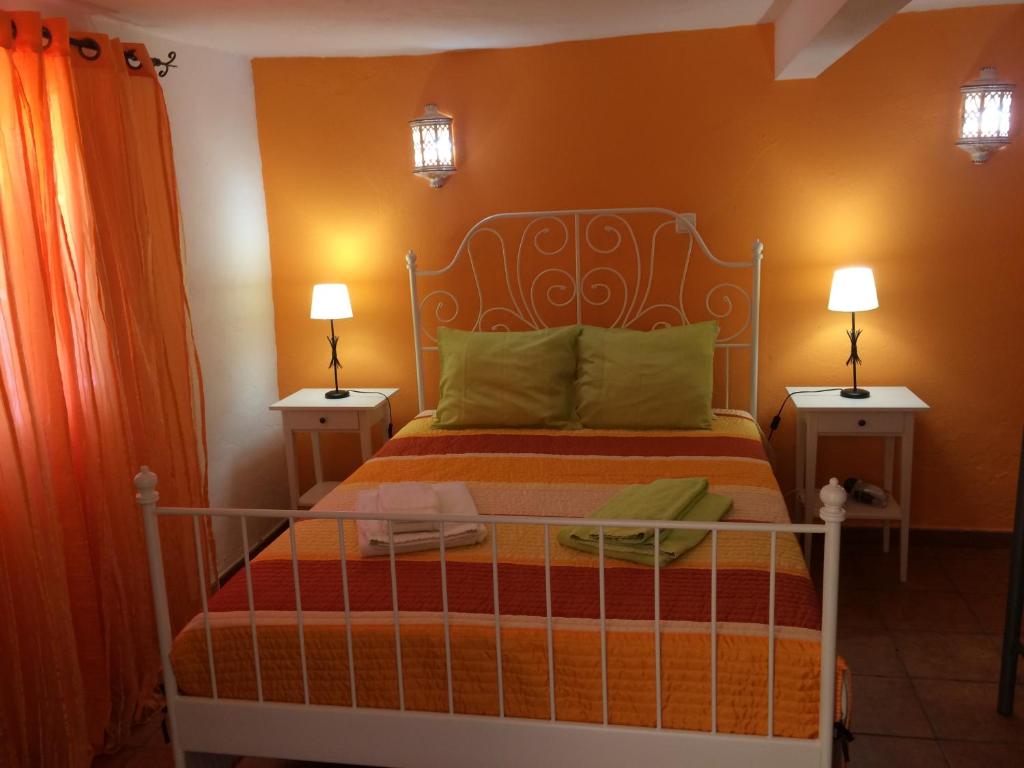 1 dormitorio con 1 cama con 2 mesitas de noche en Cerro da Janela Hostel, en Alte