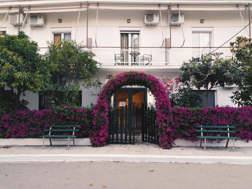 a building with a gate covered in flowers at Hotel Ritsa in Kamena Vourla