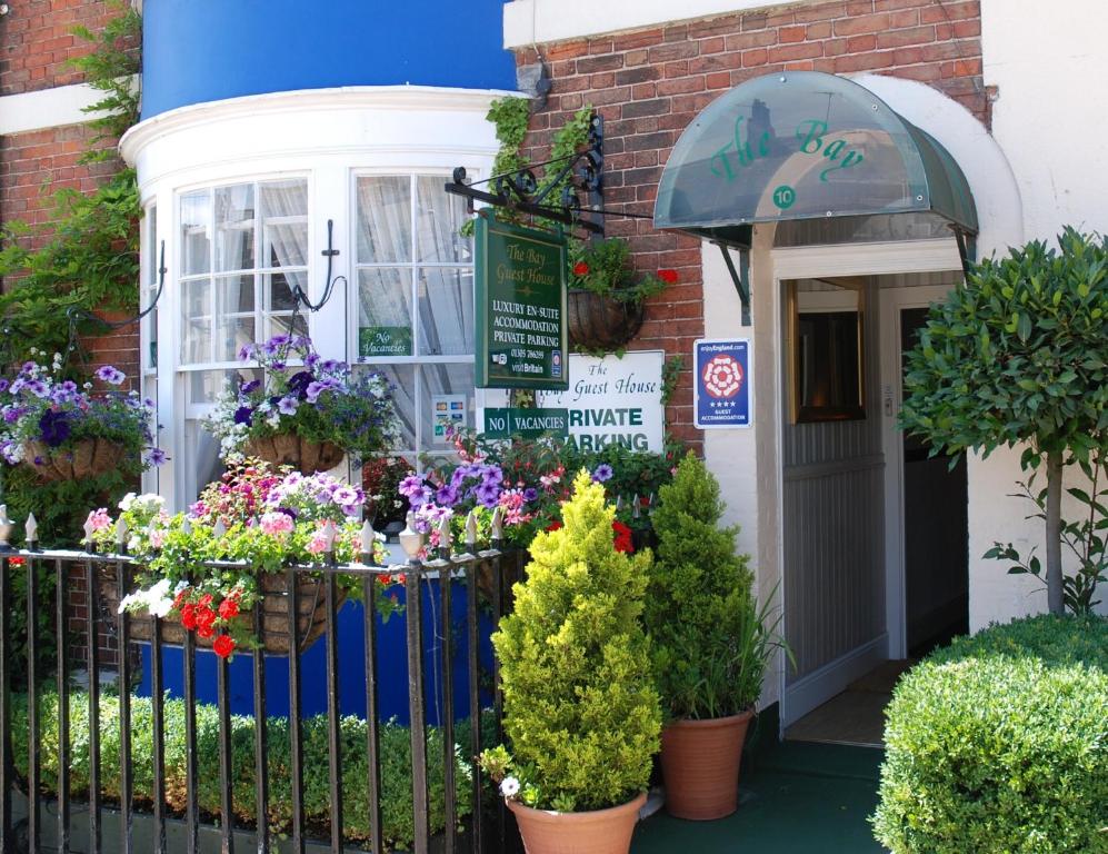 a flower shop with flowers in front of a building at The Bay Guest House in Weymouth