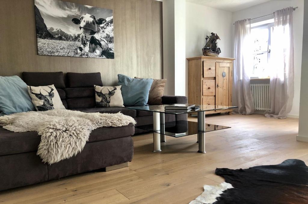 a living room with a couch and a glass table at Apartment SEEnsucht - Tolle Lage, nah am See, perfekt für Familien in Schliersee