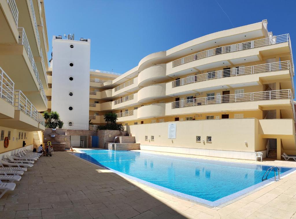 a swimming pool in front of a building at Marina Vilamoura Apartment in Vilamoura