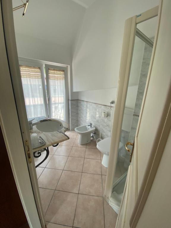 łazienka z łóżkiem, umywalką i wanną w obiekcie Hotel Edoné w mieście Roe
