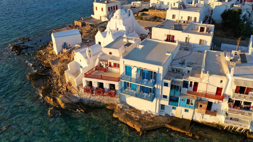 wyspa z białymi budynkami w wodzie w obiekcie Bluetopia Suites w mieście Mykonos