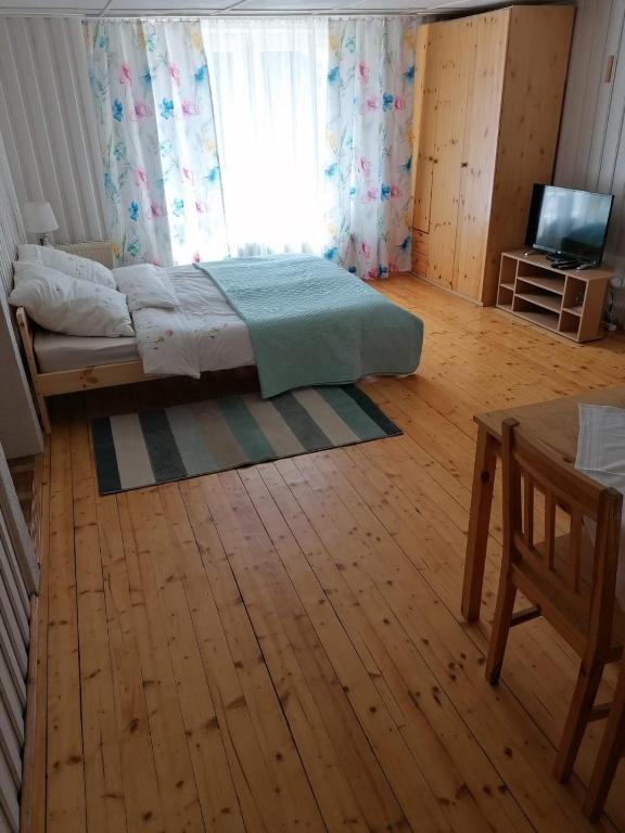 a bedroom with a bed and a window and a wooden floor at U Eli in Wambierzyce
