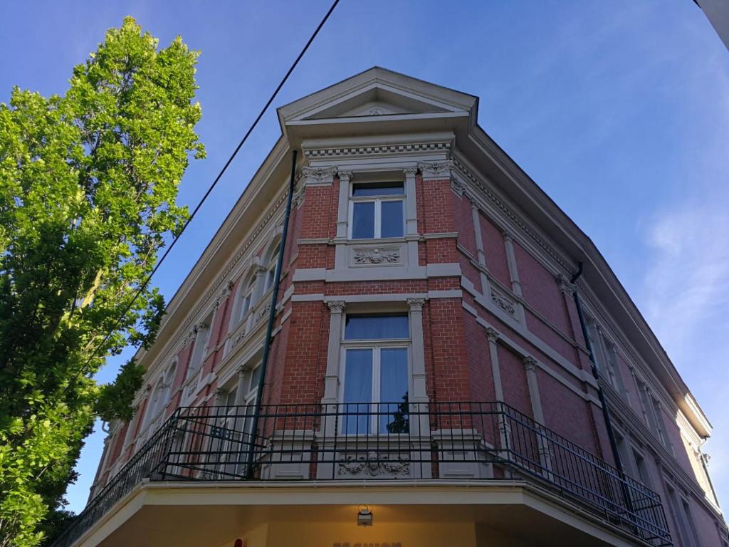 ein hohes rotes Backsteingebäude mit einem Balkon in der Unterkunft Gäste-Liesel Bad Pyrmont in Bad Pyrmont