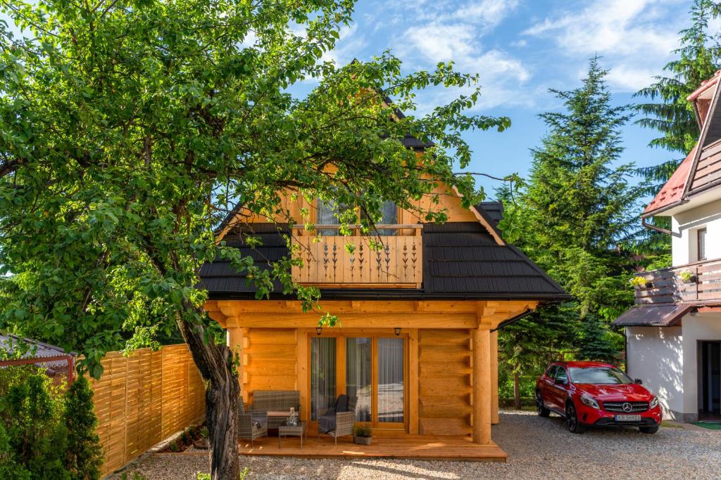 a log cabin with a balcony on top of it at Góralski Domek Zornicka in Zakopane