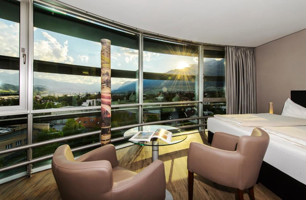Habitación de hotel con cama y ventana grande en Parkhotel Hall in Tirol en Hall in Tirol