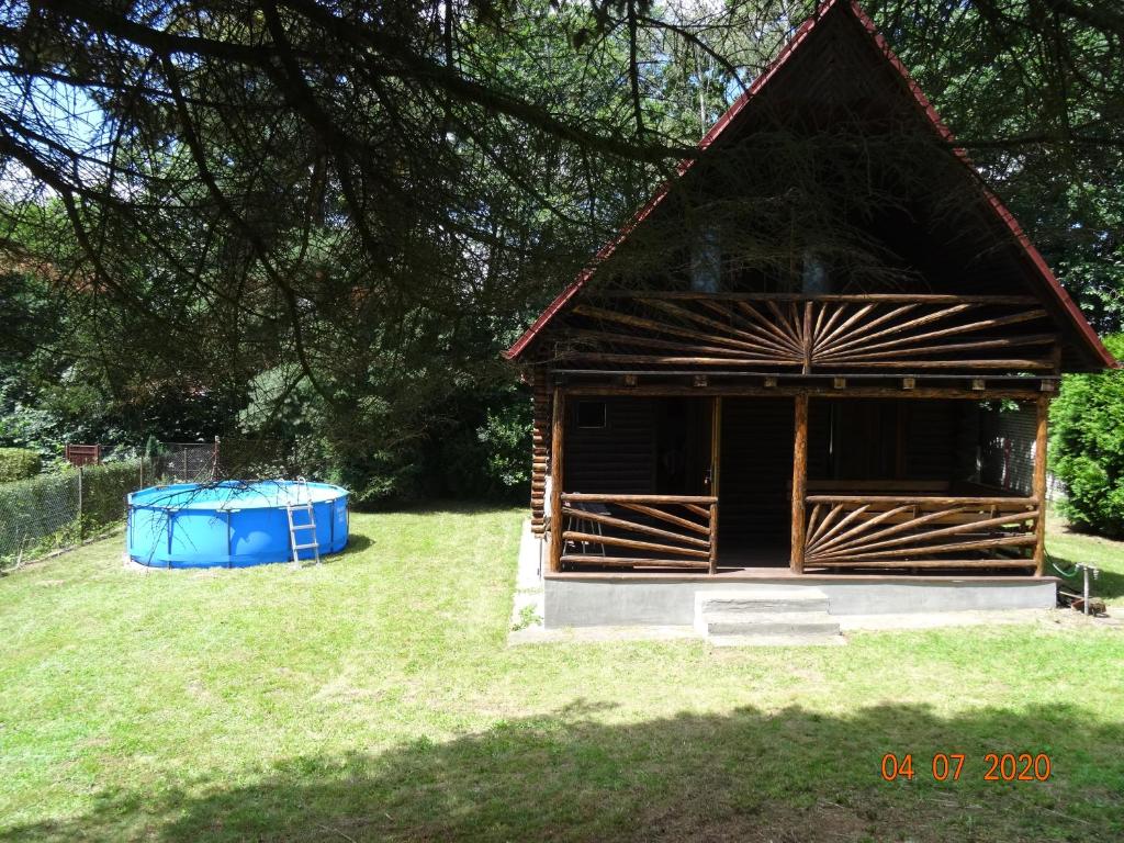 a small cabin with a blue tub in the grass at Chata Kamberk in Kamberk