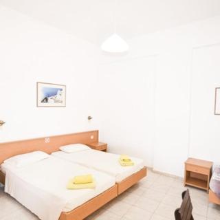 a bedroom with a bed with two yellow towels on it at PHILIPPOS STUDIOS & APT in Lindos