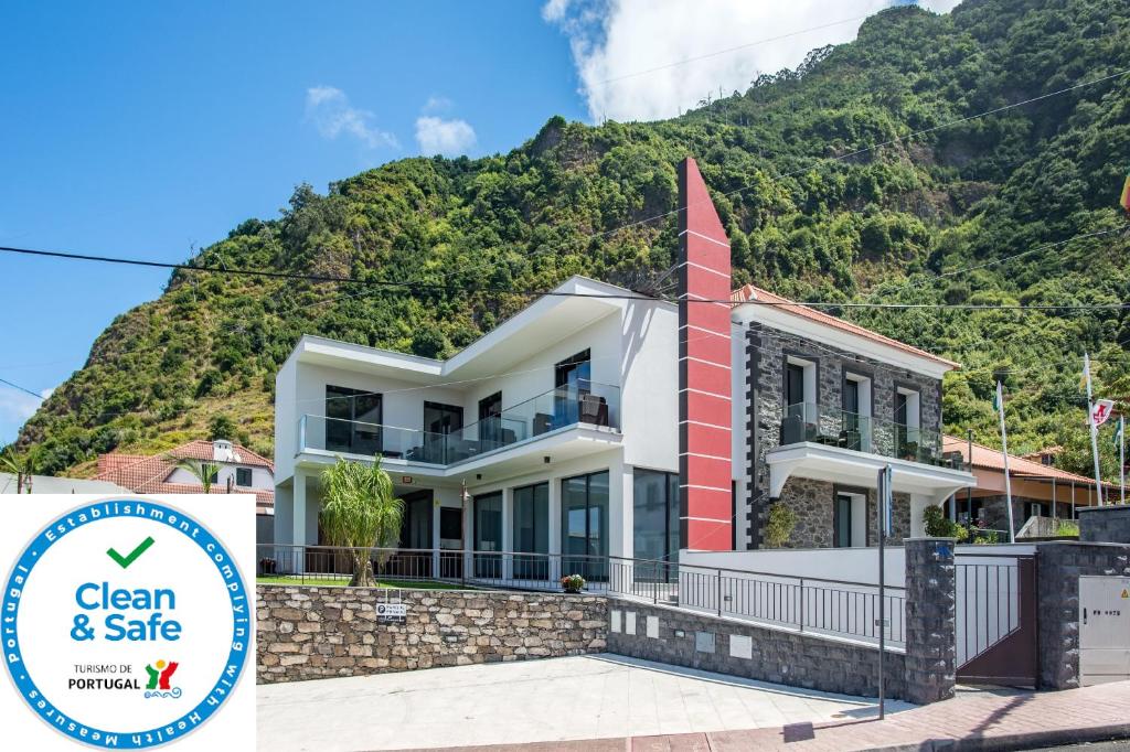 uma casa com uma montanha ao fundo em Enxurros House em Ponta Delgada