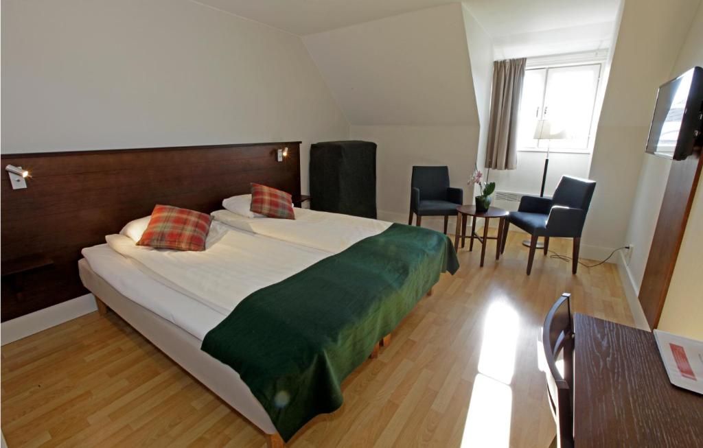 a bedroom with a large bed and a table and chairs at Rasta Kalmar in Kalmar