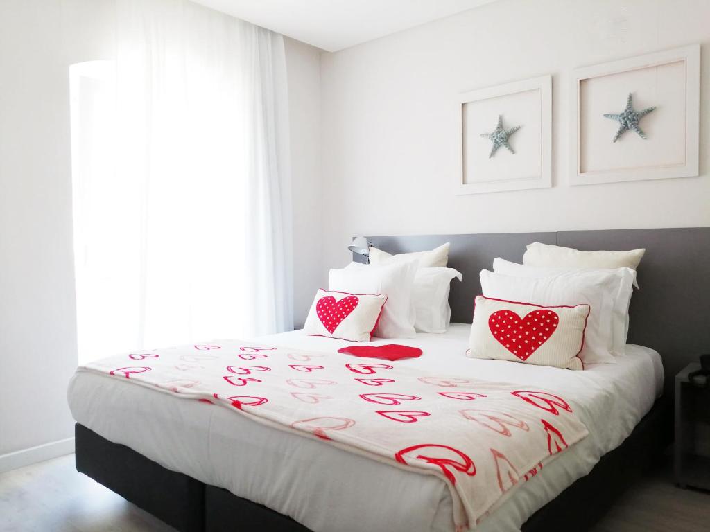a bedroom with a bed with red hearts on it at Hotel Mar Bravo in Nazaré