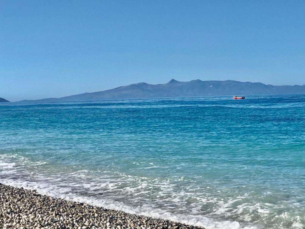a boat in the water on a beach at Violet Village in Borsh