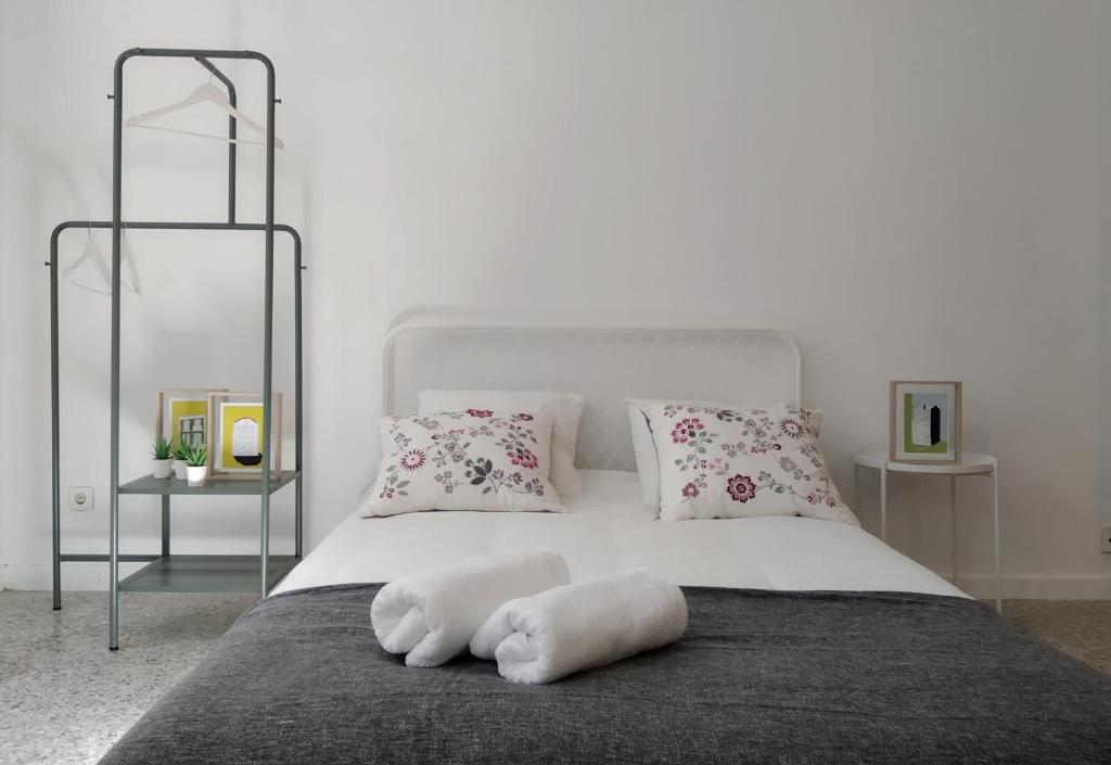 una camera con un letto bianco con due cuscini di APT Slow City Hostel a Pontevedra