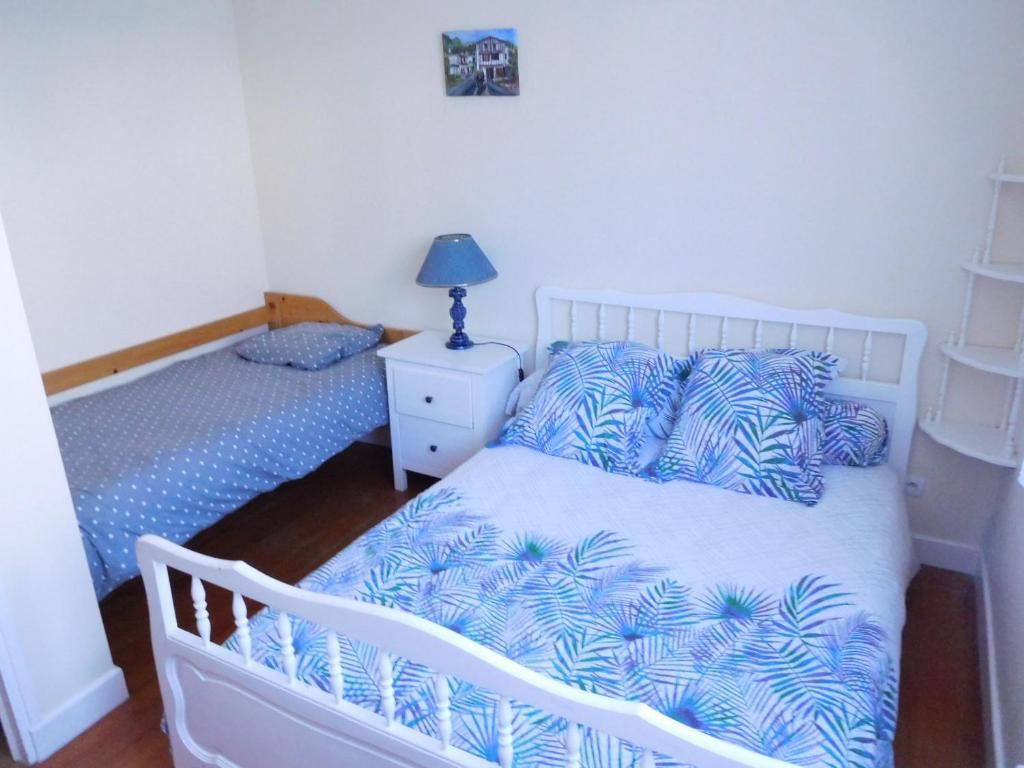 een slaapkamer met een wit bed met blauwe kussens bij Arrantzaleak in Hendaye