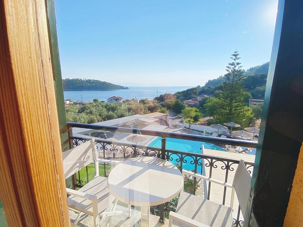 a balcony with a table and chairs and the ocean at Panormos Beach Hotel Skopelos in Panormos Skopelos
