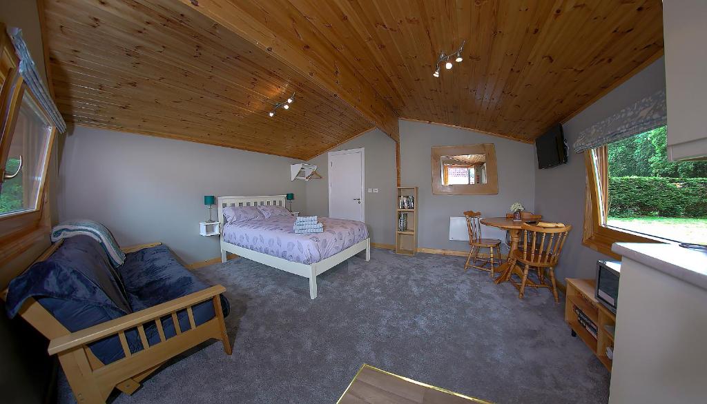 um quarto com uma cama e uma mesa num quarto em The Cabin @ Willowmere (Garden Log Cabin) em Clane