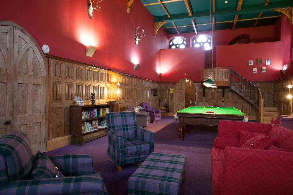 a living room with a pool table in it at Loch Ness Moat House Apartments in Fort Augustus