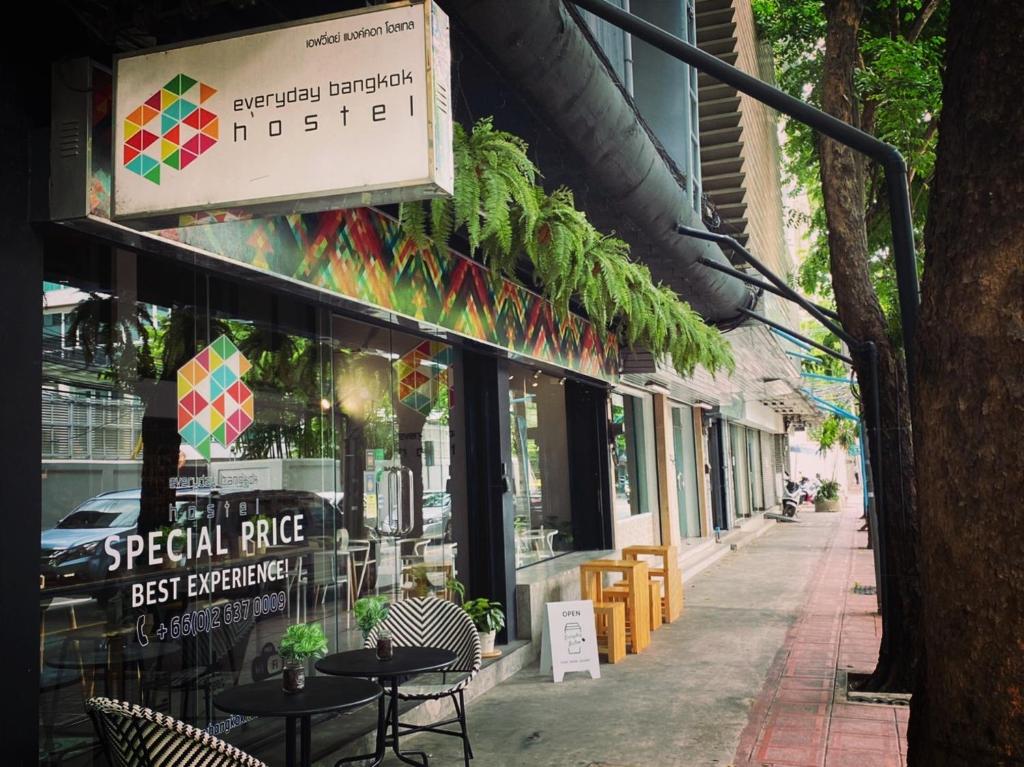 a restaurant with tables and chairs on a sidewalk at Everyday Bangkok Hostel in Bangkok