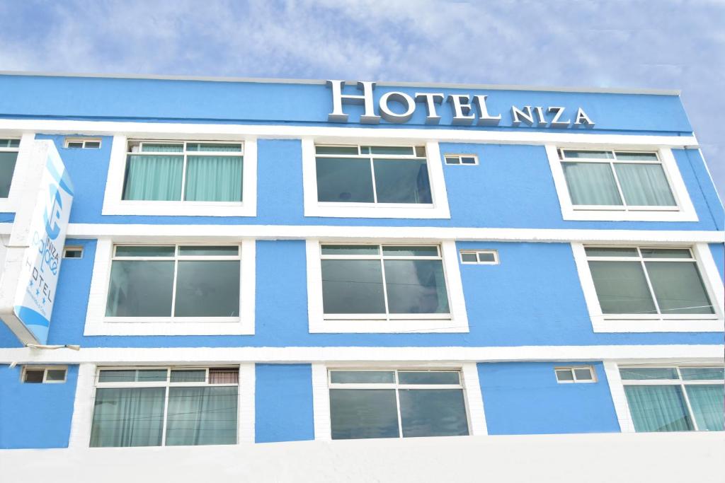 un edificio azul con un letrero de hotel en él en Hotel Niza Zona Piel, en León