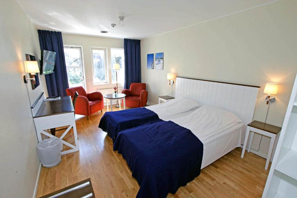 a bedroom with a bed and a living room at Nordby Hotell in Lervik
