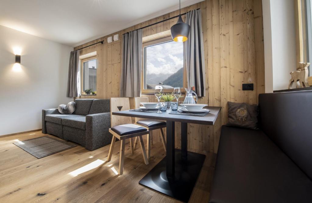 - un salon avec une table et un canapé dans l'établissement Casteller Apartment Deluxe, à La Villa