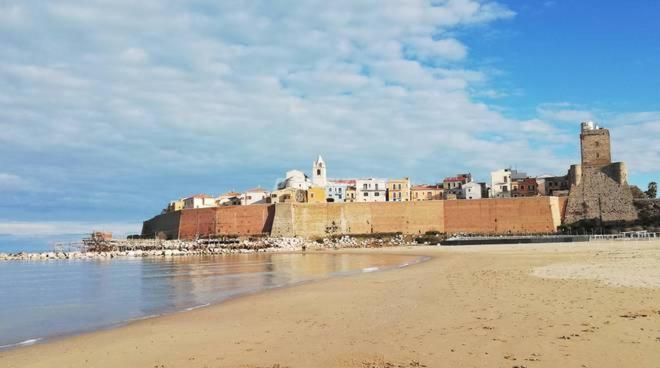 Splendido appartamento a due passi dal mare في تيرمولي: شاطئ فيه قلعة وسط الماء